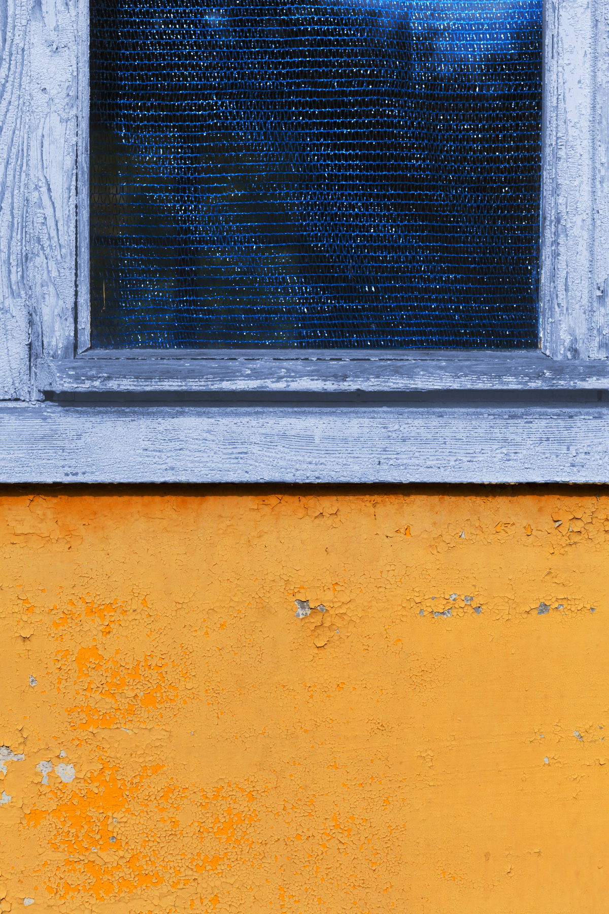 Синее окно на желтой стене