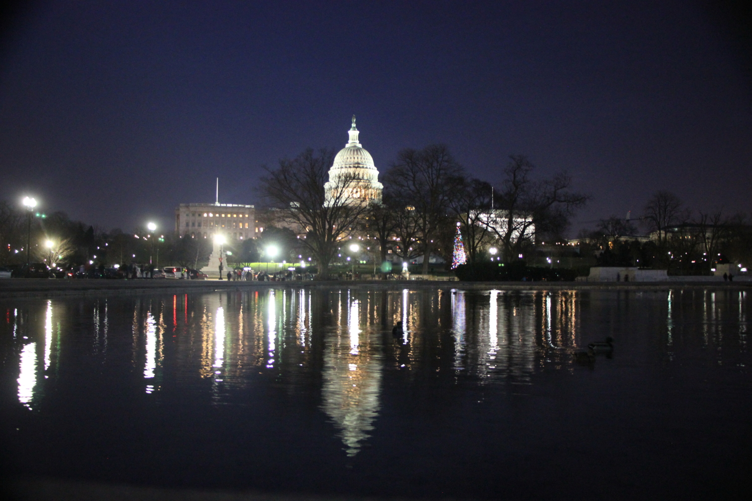 Здание конгресса США с отражением в водоёме ночью.