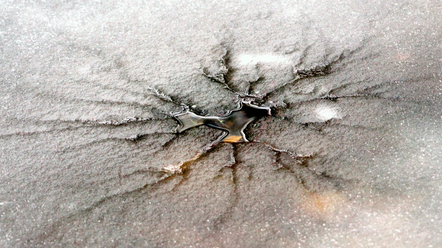 Трещины на льду от брошенного камня.
