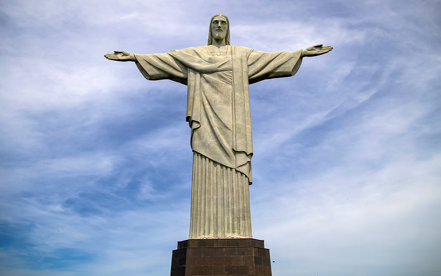 Статуя Иисуса Христа и два глаза в облаках.