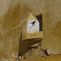 Часы на стене крепости в Марокко