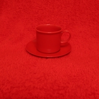 На красном столе, стоит красная чашка…